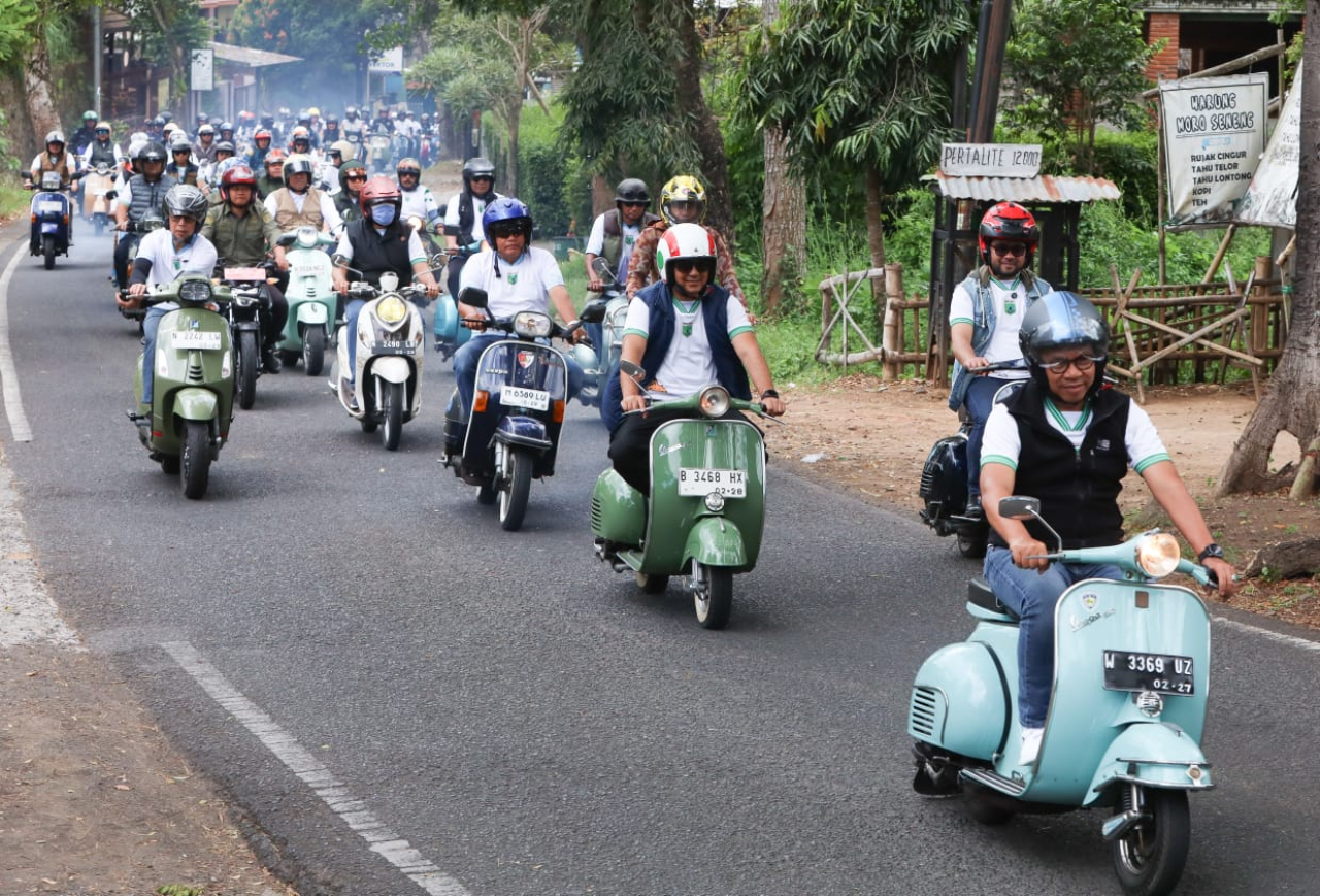 Wali Kota Batu Nurochman naik vespa dalam pawai obor Porprov Jatim 2025. (Foto: ist)