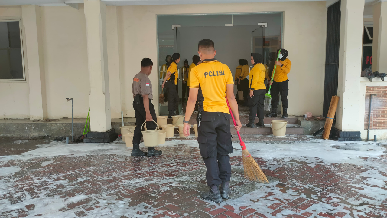 Anggota Polisi saat membersihkan Kantor Bawaslu Jatim sebelum ditempati.