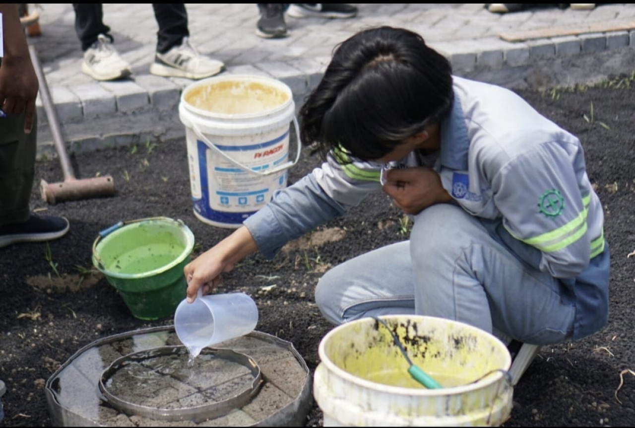 Salah satu mahasiswa ITS saat membuat paving