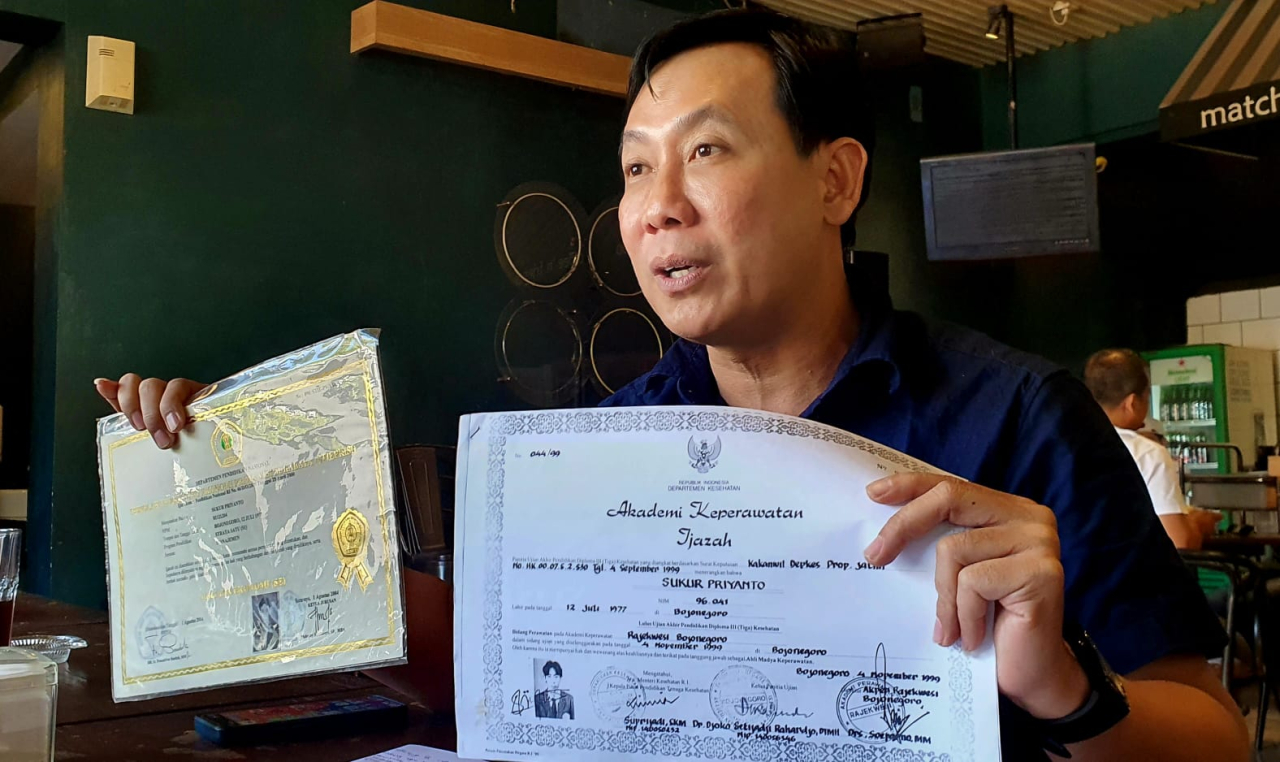 Sukur Priyanto menunjukkan ijazah asli saat memberikan klarifikasi terkait tudingan ijazah palsu menjelang Musda Demokrat Jatim, Rabu (26/8/2026).